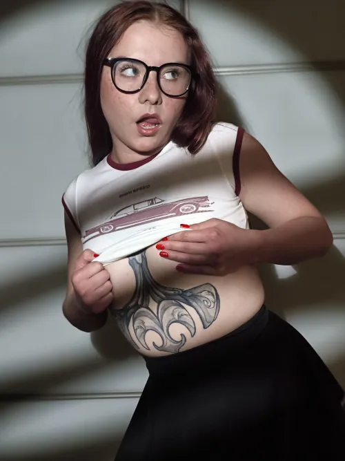 Lenses glint, breasts gripped tight