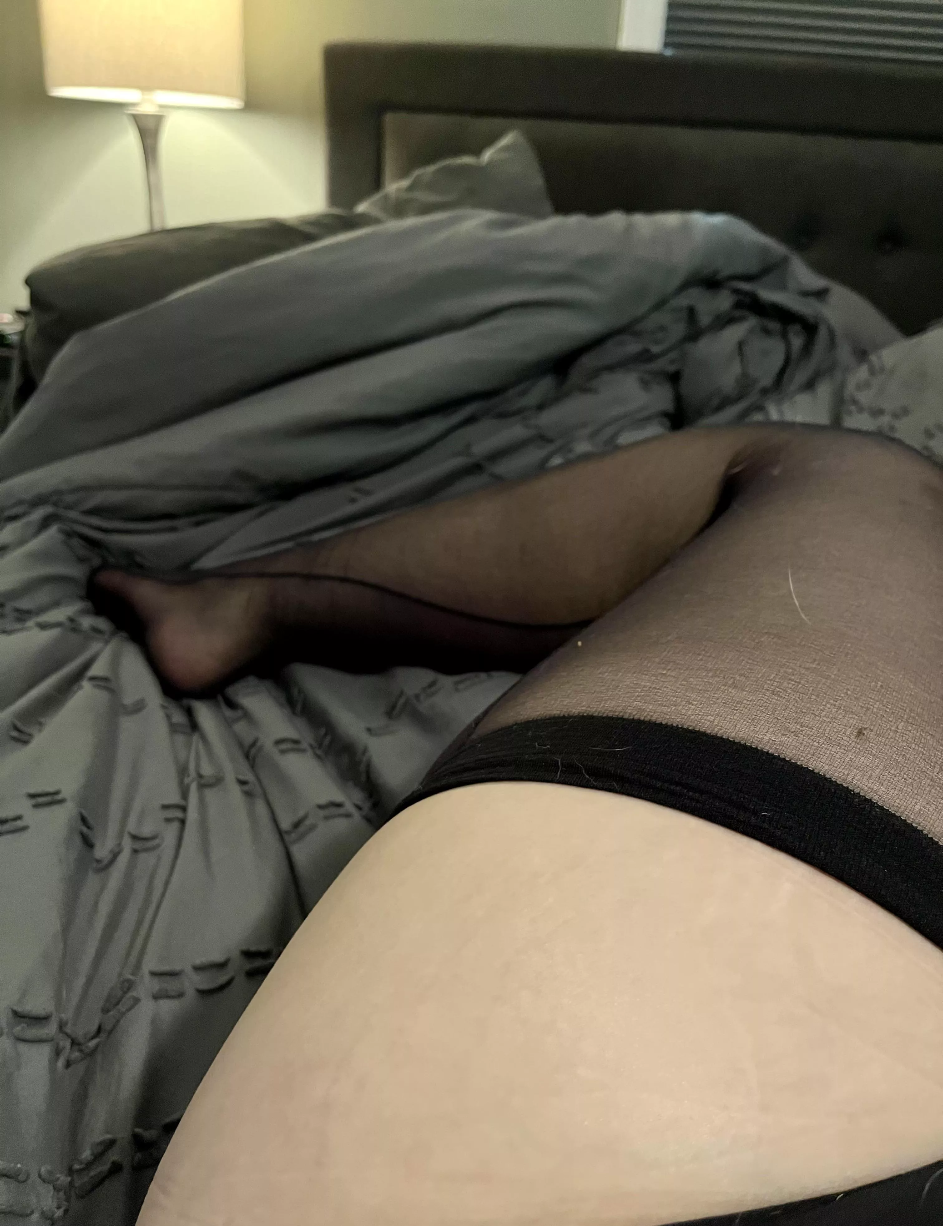 Curled up in bed in just tights and panties. 😊