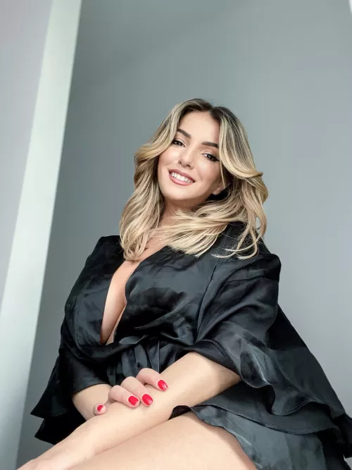 Wearing a huge smile and a satin robe.